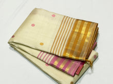 Sahana- Mesmerizing Offwhite with Golden Mustard and Pink handwoven Pure Jari Kanjivaram Silk with beautiful silk buttas woven body with Ganga Jamuna striped jari and silk threads woven beautiful borders rich pallu and contrast woven blouse