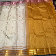 Sahana- Mesmerizing Offwhite with Golden Mustard and Pink handwoven Pure Jari Kanjivaram Silk with beautiful silk buttas woven body with Ganga Jamuna striped jari and silk threads woven beautiful borders rich pallu and contrast woven blouse