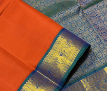 Vaibhogam- Gorgeous Burnt Orange with Peacock Blue Handwoven Pure 2g Jari Korvai Kanjivaram Silk with plain body rich borders gorgeous pallu and contrast woven blouse