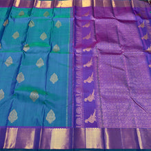 Sahana- Stunning Peacock Bluish Green with Purple Handwoven Pure 2g Jari Kanjivaram Silk with Muthukattam and Buttas woven beautiful body with rich bawanchi borders gorgeous kalakshetra kili pallu and contrast purple blouse