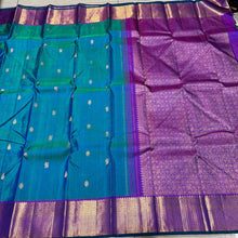 Vaibhogam- Stunning Peacock Bluish Green with Purple Handwoven Pure 2g Jari Kanjivaram Silk with beautiful buttas woven body rich mayilkan and thambalam buttas woven borders rich buttas woven pallu and contrast woven blouse with green selvedges