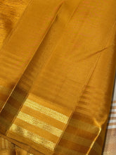 Sahana- Mesmerizing Offwhite with Golden Mustard and Pink handwoven Pure Jari Kanjivaram Silk with beautiful silk buttas woven body with Ganga Jamuna striped jari and silk threads woven beautiful borders rich pallu and contrast woven blouse