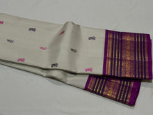 Vaibhogam- Gorgeous Offwhite with Purple Handwoven Pure Zari Korvai Kanjivaram Silk with Pattu Buttas woven body with rich varisaipet borders with beautiful pallu and contrast woven purple blouse