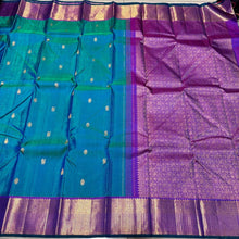 Vaibhogam- Stunning Peacock Bluish Green with Purple Handwoven Pure 2g Jari Kanjivaram Silk with beautiful buttas woven body rich mayilkan and thambalam buttas woven borders rich buttas woven pallu and contrast woven blouse with green selvedges
