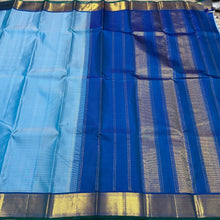Nayaki- Beautiful Handwoven Pure Jari Kanjivaram Silk in a pastel blue with peacock blue combination with self striped body , rich mayilkan woven bawanchi borders rich seer pallu and contrast blouse