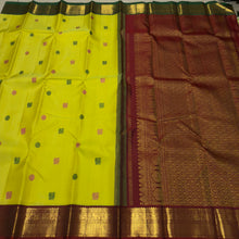 Vaibhogam- Stunning Lemoney Green tinted Yellow with Burgundy Maroon in a Handwoven Pure Jari Korvai Kanjivaram Silk with beautiful pattu buttas woven body rich borders gorgeous pallu and contrast woven blouse