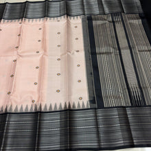 Saraswati-Gorgeous Handwoven Pure Zariless Korvai Kanjivaram Silk in a beautiful and rare peachish sandal shade with Black combination with beautiful kasuti style buttas woven beautiful body with varisaipet borders rich pallu and contrast woven blouse