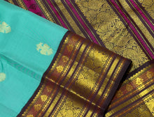 Vaibhogam- Stunning Turquoise Double tone Bluish Green Body with Deep Coffee Brown Handwoven Pure Jari Korvai Kanjivaram Silk with beautiful buttas woven body rich meenakari work woven borders and pallu and contrast woven blouse