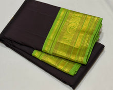 Vaibhogam- Gorgeous Deep Blackish Kanchana Brown with Parrot Green Handwoven Pure Jari Korvai with Buttas Kanjivaram Silk with beautiful double peacock motifs woven in a clover shaped motif with rich borders pallu and contrast woven blouse