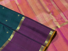 Sahana- Stunning Bottle Green with Ganga Jamuna Borders with buttas with contrast kanakambaram Orange Pallu and blouse in a beautiful Handwoven Pure 2g Jari Kanjivaram Silk Beauty