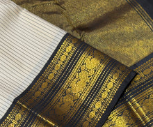 Vaibhogam- Beautiful Offwhite with Black Handwoven Pure2g Jari Korvai Kanjivaram Silk with beautiful striped body with rich borders stunning rich seer pallu and contrast woven beautiful black blouse