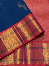 Vaibhogam- Gorgeous Peacock Blue with Orange Pink Handwoven Pure Jari Korvai Kanjivaram Silk with beautiful peacock buttas woven body with rich borders pallu and contrast woven blouse