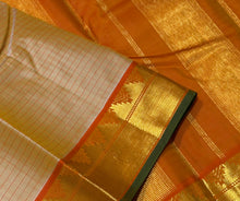 Sahana- Gorgeous Beige with Rustic Orange Handwoven Pure Jari Kanjivaram Silk with Muthukattam checks woven body with beautiful borders with green selvedges rich seer pallu and contrast woven blouse