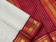 Offwhite with Arakku Red and Emerald Green Ganga Jamuna Korvai Borders with Plus buttas in silk threads woven all over the body with rich arakku pallu and simple green pallu on the other side which can be worn on either sides with a single arakku blouse