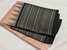 Saraswati-Gorgeous Handwoven Pure Zariless Korvai Kanjivaram Silk in a beautiful and rare peachish sandal shade with Black combination with beautiful kasuti style buttas woven beautiful body with varisaipet borders rich pallu and contrast woven blouse