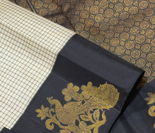 Vaibhogam- Stunning offwhite with black Handwoven Pure Jari Korvai Kanjivaram Silk with beautiful muted checks woven body with gorgeous peacocks woven on either side of the borders with beautiful pallu and contrast black blouse