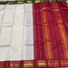 Offwhite with Arakku Red and Emerald Green Ganga Jamuna Korvai Borders with Plus buttas in silk threads woven all over the body with rich arakku pallu and simple green pallu on the other side which can be worn on either sides with a single arakku blouse