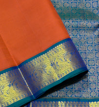 Vaibhogam- Gorgeous Burnt Orange with Peacock Blue Handwoven Pure 2g Jari Korvai Kanjivaram Silk with plain body rich borders gorgeous pallu and contrast woven blouse