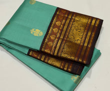 Vaibhogam- Stunning Turquoise Double tone Bluish Green Body with Deep Coffee Brown Handwoven Pure Jari Korvai Kanjivaram Silk with beautiful buttas woven body rich meenakari work woven borders and pallu and contrast woven blouse