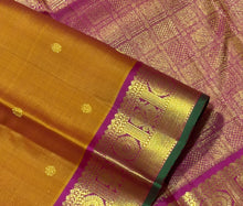 Sahana- Gorgeous Sampanga Mustard with Deep Magenta Buttas Handwoven Pure Jari Kanjivaram Silk with beautiful buttas woven body with mayil chakram motifs woven borders with green selvedges rich pallu and contrast woven blouse