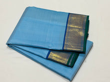 Nayaki- Beautiful Handwoven Pure Jari Kanjivaram Silk in a pastel blue with peacock blue combination with self striped body , rich mayilkan woven bawanchi borders rich seer pallu and contrast blouse