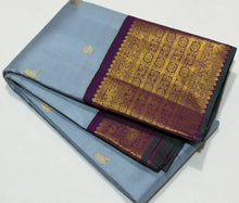 Vaibhogam- Mesmerizing Powder Greyish Blue with Deep Purple Handwoven Pure 2g Jari Korvai with Bird Buttas Woven Kanjivaram Silk with rich varisaipet borders with green selvedges gorgeous pallu and contrast woven blouse