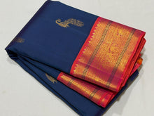Vaibhogam- Gorgeous Peacock Blue with Orange Pink Handwoven Pure Jari Korvai Kanjivaram Silk with beautiful peacock buttas woven body with rich borders pallu and contrast woven blouse